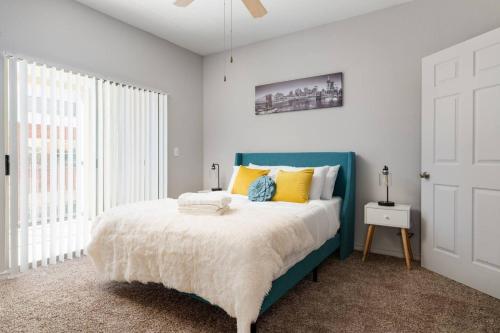 Un dormitorio con una cama azul con almohadas amarillas en Affordable 2BR Farmers Branch en Farmers Branch