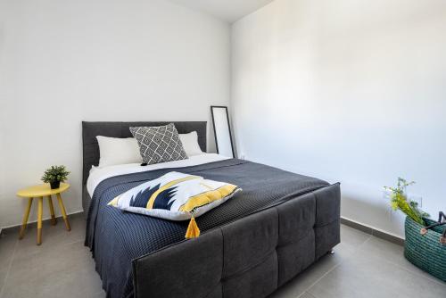 特拉維夫的住宿－HaCarmel Market Vibrat Apartment by Sea N' Rent，一间卧室配有一张带黑色床头板的床