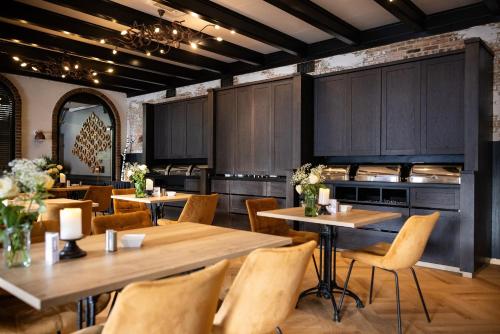 un restaurant avec des tables et des chaises en bois dans l'établissement Hotel De Rustende Jager, à Nieuw-Vennep