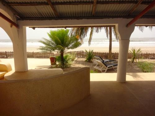 vistas a la playa desde el porche de una casa de playa en HOTEL DU BAR DE LA MER CAP SKIRRiNG en Kabrousse