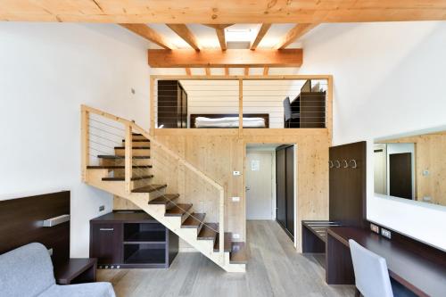 a staircase in a living room with wooden ceilings at Hotel Montana in Vason