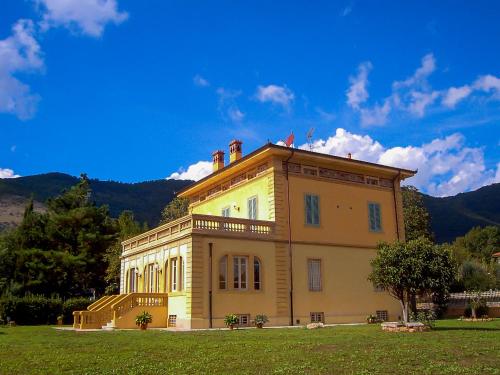 a large building on top of a grass field at Marta Guest House in Santa Maria del Giudice