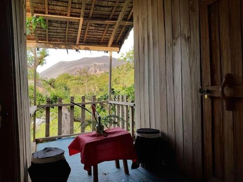 um quarto com uma mesa e vista para uma montanha em Tanna Eagle twin volcano view tree house em White Sands