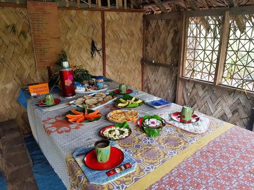 einen Tisch mit Teller mit Lebensmitteln darüber in der Unterkunft Tanna Eagle twin volcano view tree house in White Sands