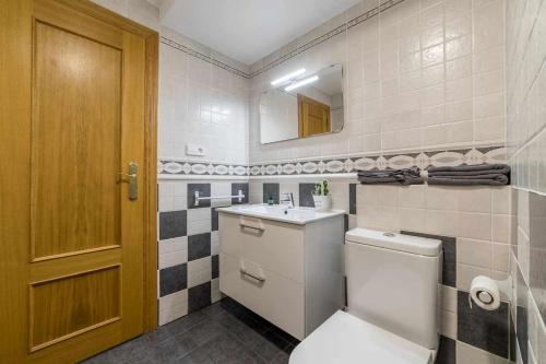 a bathroom with a toilet and a sink and a mirror at Piso Carolina in Valencia