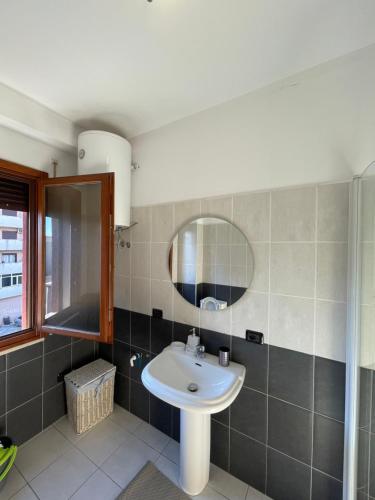 y baño con lavabo y espejo. en Gega Apartment, en Shkodër