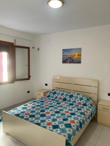 a bedroom with a bed with a quilt on it at Gega Apartment in Shkodër