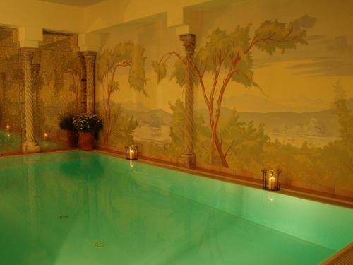 a swimming pool in a room with a painting on the wall at Sammareier Gutshof in Bad Birnbach