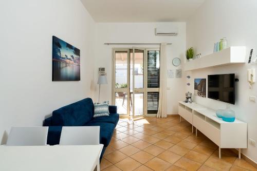 a living room with a blue couch and a tv at Dimore Anny in San Lorenzo