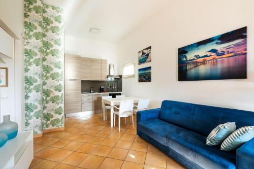 a living room with a blue couch and a kitchen at Dimore Anny in San Lorenzo