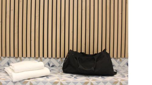 eine schwarze Tasche auf dem Boden mit Handtüchern in der Unterkunft Logis Hôtel de l'Europe in Poitiers
