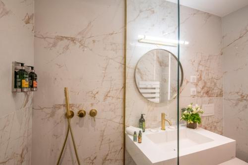 a bathroom with a shower with a sink and a mirror at Hôtel Petit Palais in Nice