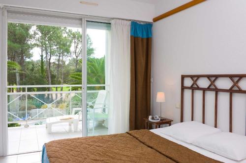une chambre avec un lit et un balcon avec vue dans l'établissement Madame Vacances Les Appartements de Moliets, à Moliets-et-Maa