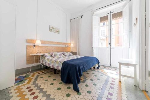 a bedroom with a bed and a desk and a window at Piso Visitacion in Valencia