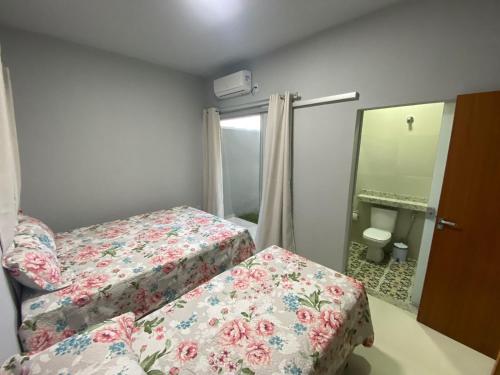 Habitación pequeña con 2 camas y espejo. en Casas Amarelas II - Prado BA en Guarani