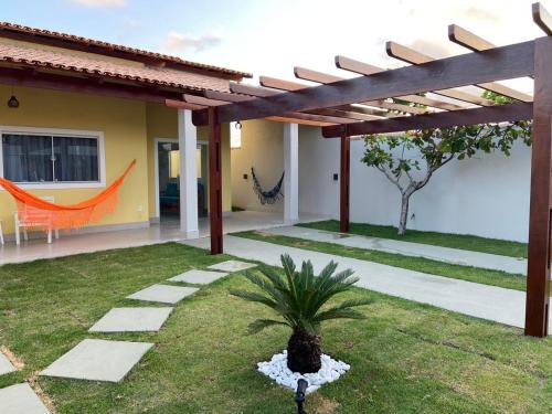 una casa con un patio con una palmera en el patio en Casas Amarelas II - Prado BA en Guarani