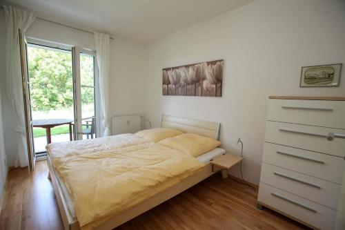a bedroom with a bed and a dresser and a window at Landhaus Kaiser zum Strande - b47256 in Bastorf