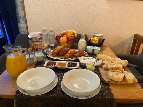 a table with plates of food and bread and fruit at Moon River Bellac Chambre d'hotes in Bellac
