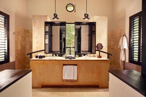 a bathroom with two sinks and a large mirror at Hacienda Uayamon in Uayamón