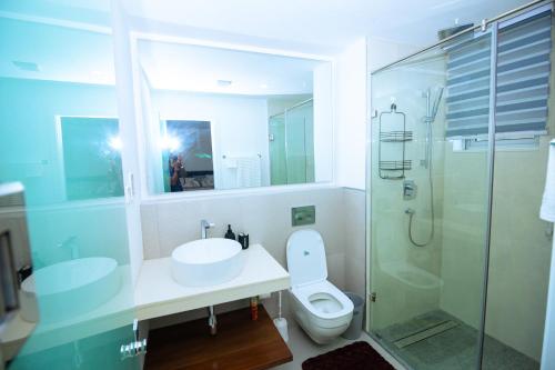 a bathroom with a sink and a toilet and a shower at The Pavilion 1BDR Luxury Apt in Accra