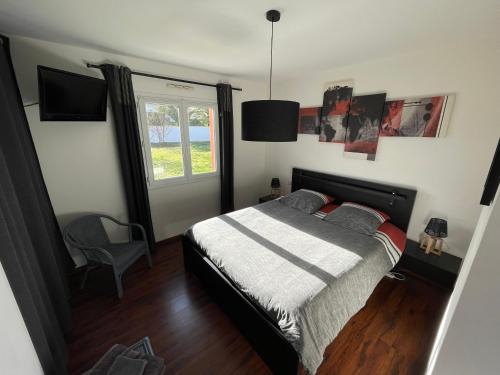 Schlafzimmer mit einem Bett und einem Fenster in der Unterkunft Aux Aigrettes in Gousse