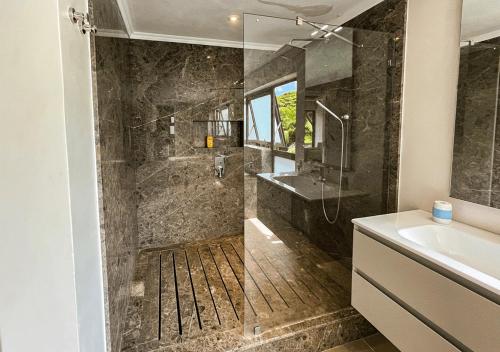 y baño con ducha y lavamanos. en Villa Fairways - Private, Golf & Luxe en Centre de Flacq