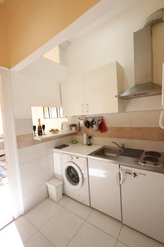 a white kitchen with a washing machine in it at Studio Jasna in Novi Sad