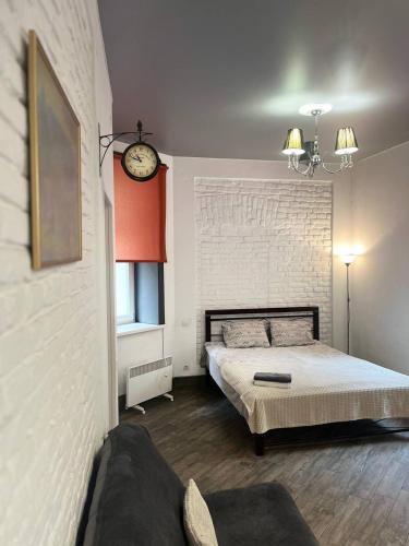 een slaapkamer met een bed en een klok aan de muur bij Shpytalna Apartments in Lviv