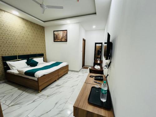 una camera con letto e tavolo con televisore di HAPPY HABITAT GUEST HOUSE a Greater Noida