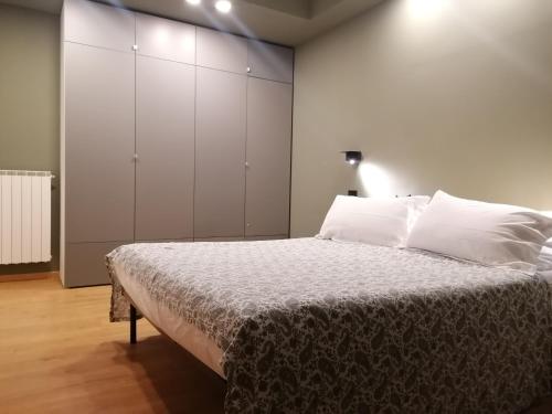a bedroom with a large bed with white cabinets at Arona 03 centralissimo ampio bilocale con garage in Arona
