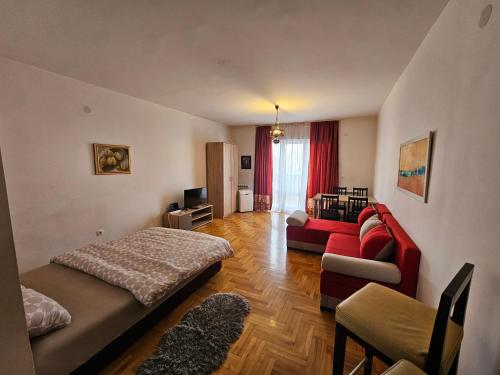 een woonkamer met een rode bank en een rode bank bij apartament 29 in Belgrado