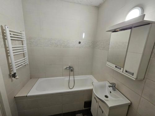 een witte badkamer met een bad en een wastafel bij apartament 29 in Belgrado