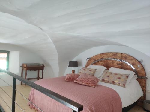 una camera con un letto e una coperta rosa di Charme et authenticité dans une ferme. a Lourmarin