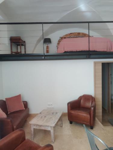 a living room with a bed and a couch and a table at Charme et authenticité dans une ferme. in Lourmarin