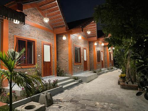 Un patio de un edificio de ladrillo con plantas y luces. en Nhà Điệp Bungalow Ninh Binh, en Ninh Binh