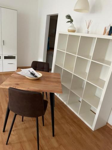 a dining room with a table and a book shelf at Appartement Donauwelle 2 in Passau