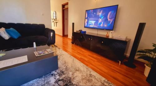 a living room with a couch and a flat screen tv at Rossyln Home close to Village Market, UN and Two Rivers Mall in Nairobi