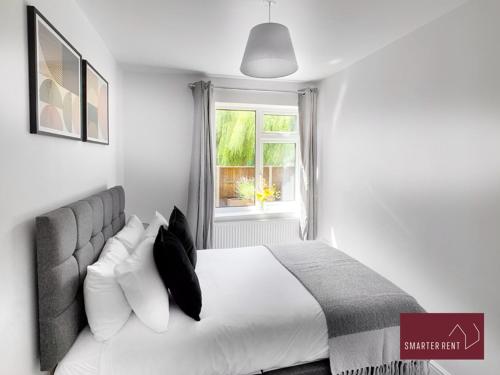 a bedroom with a white bed and a window at Sunninghill Village - 2 Bed - Parking and garden in Ascot