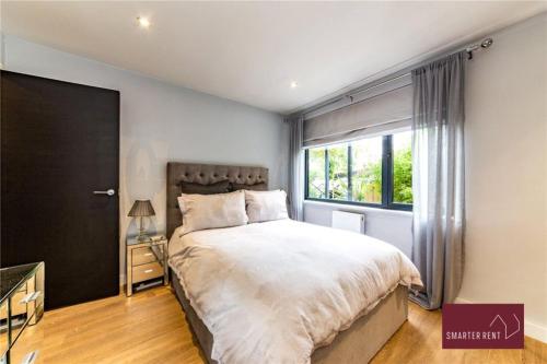 a bedroom with a large bed and a window at Wooburn Green - Modern One Bedroom Apartment in Bourne End
