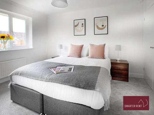 a bedroom with a large bed with pink pillows at Bisley - 2 Bedroom House - Front Garden and Parking in Bisley