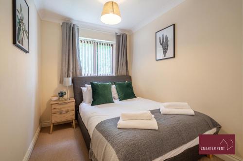 ein Schlafzimmer mit einem Bett mit grünen Kissen darauf in der Unterkunft Maidenhead - 2 Bed & parking in Maidenhead
