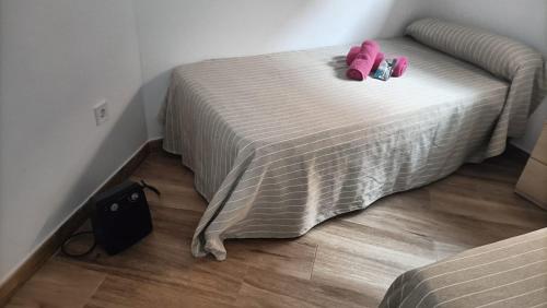 a bedroom with a bed with pink shoes on it at APARTAMENTOS LUZ DE LA BAHÍA SUR CADIZ San Fernando in San Fernando