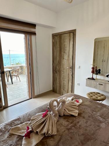 a room with a bed with a swan on it at Anemos Villa Stegna in Archangelos