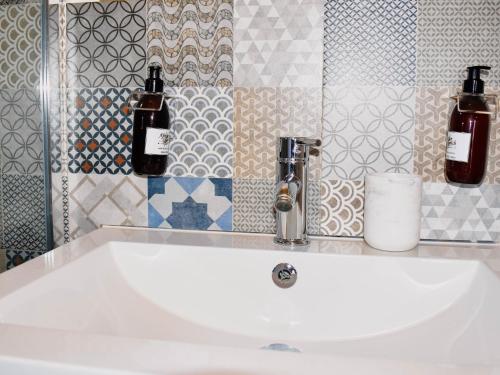 - un lavabo dans la salle de bains avec 2 bouteilles dans l'établissement Serene Guest Manor, à Johannesbourg