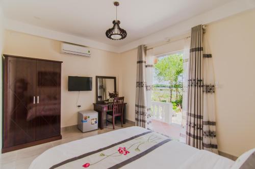 a bedroom with a bed and a window at The Moon River Homestay & Villa in Hoi An