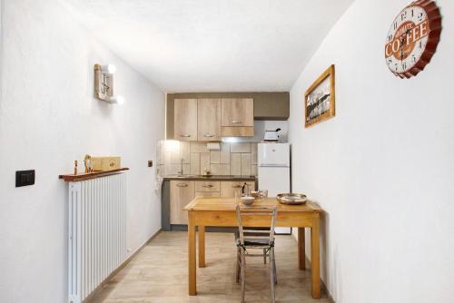 a kitchen with a wooden table and a refrigerator at Il Capriolo Aosta in Aosta
