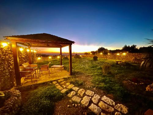 einen Pavillon mit einem Tisch und Stühlen auf einem Feld in der Nacht in der Unterkunft Gaia Holiday Home in San Lawrenz