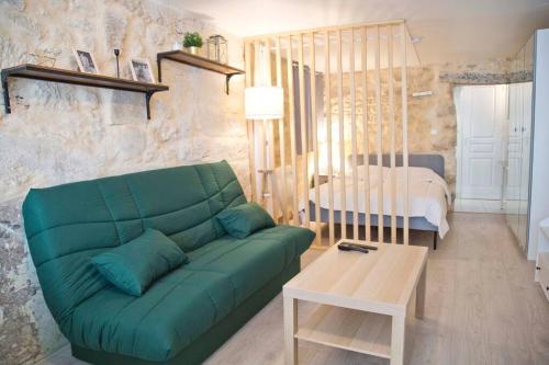 un salon avec un canapé vert et une chambre dans l'établissement Nice studio in the 5th, à Paris