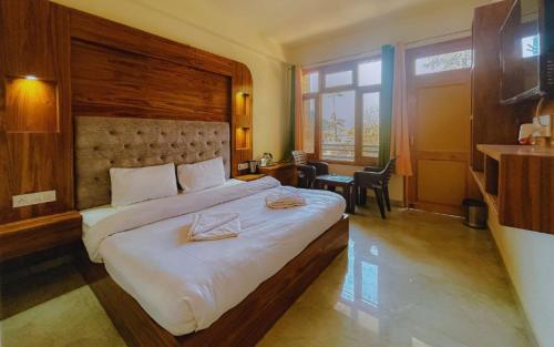 a hotel room with a large bed and a desk at Pinewood by Offlimits Homes in Kasol