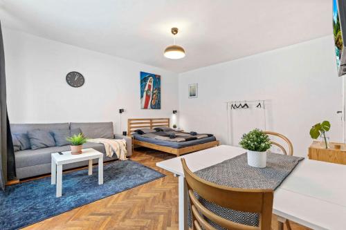 a living room with a couch and a table at Cosy Studio 10 min Center in Bratislava